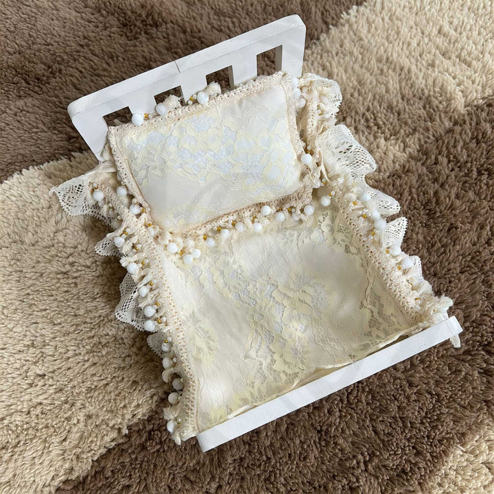 A 2-piece set featuring a newborn blanket and pillow with vintage pearl trim, lace details, and ruffled edges, for newborn photography props.