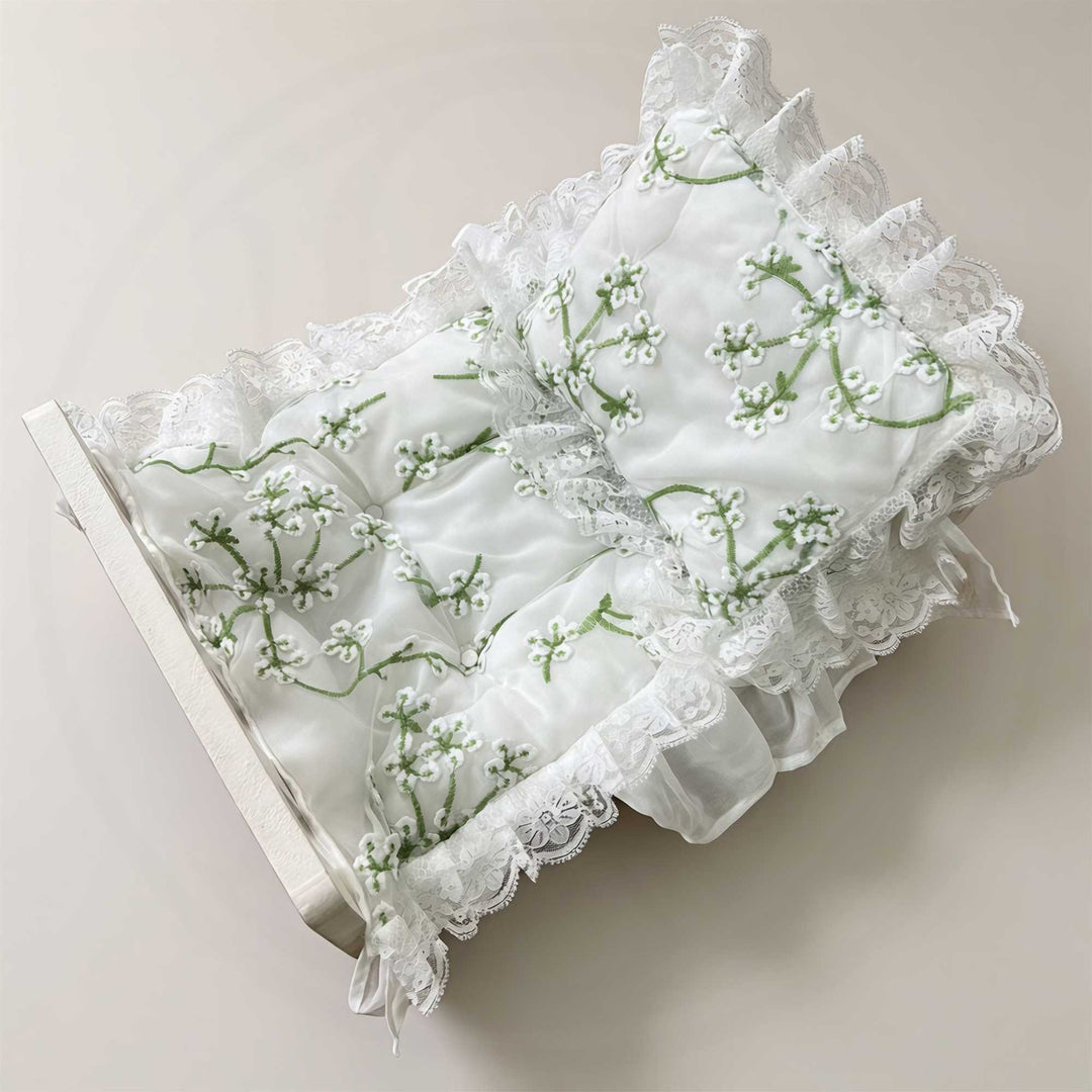 A 2-piece set featuring a newborn blanket and pillow with green floral embroidery and lace trim for newborn. photography.