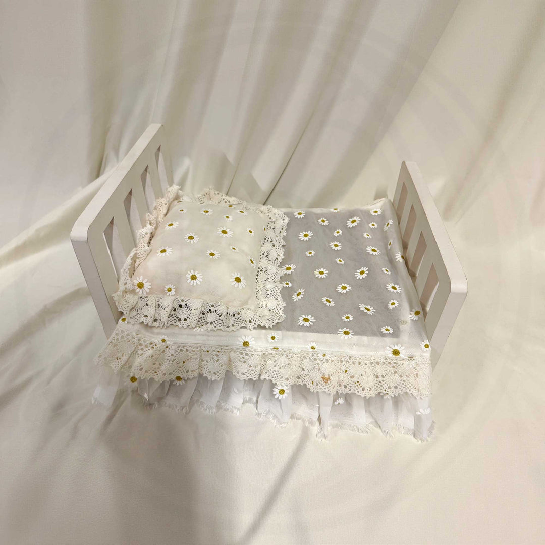 A 2-piece newborn photography props set featuring a chiffon daisy print pillow and blanket with lace trim.