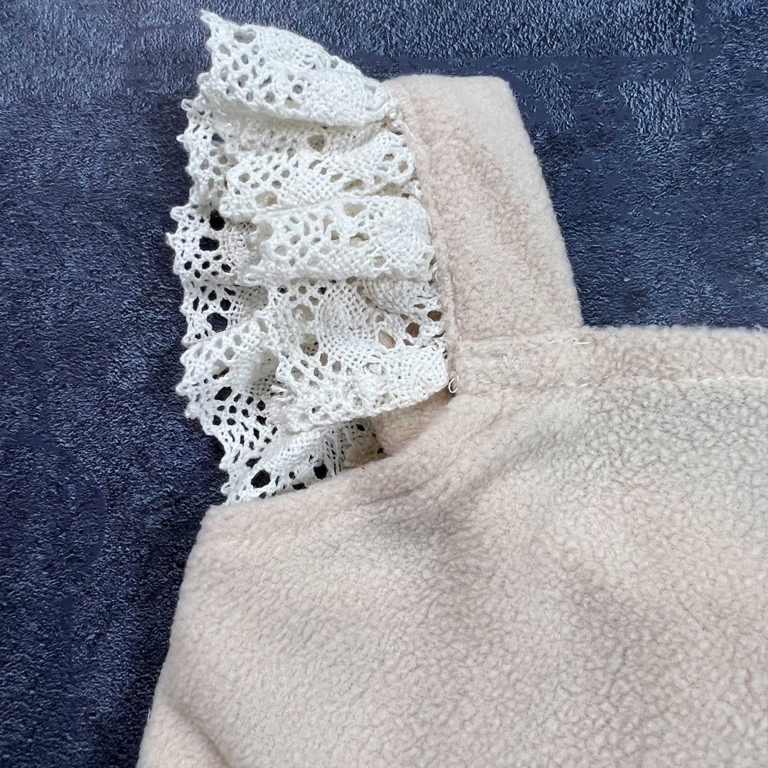 A close-up view of a lace trim ruffled romper.