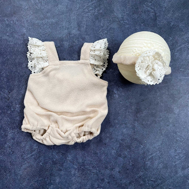 The flat lay shows a polar fleece romper with lace ruffle sleeves and a headband with flower.