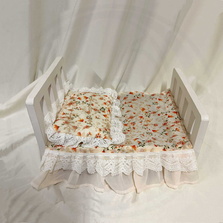A 2-piece set featuring a newborn blanket and pillow with orange floral print and lace trim for newborn photography.