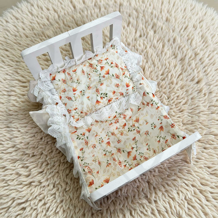A 2-piece set featuring a newborn blanket and pillow with orange floral print and lace trim for newborn photography.