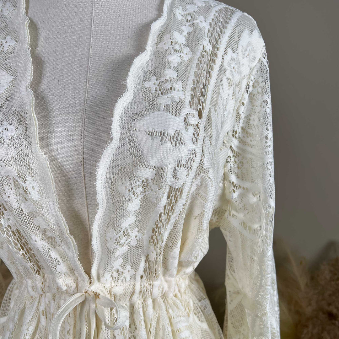 A beige lace ,Abrota dress with intricate lace patterns throughout.