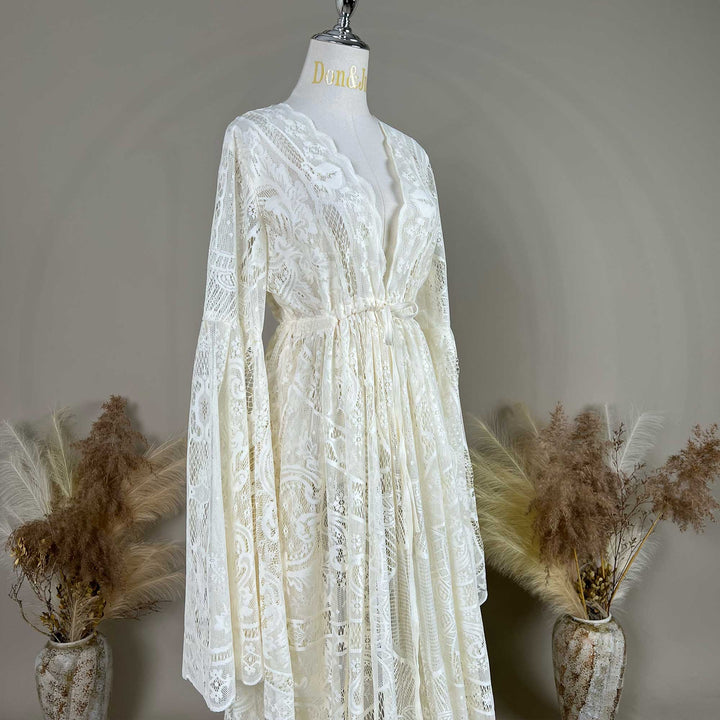 A beige lace ,Abrota dress with long bell sleeves and a V-neckline, displayed on a mannequin. 