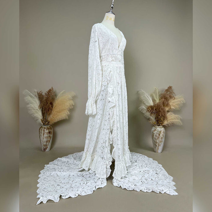 A side view of the white lace gown on a mannequin shows the silhouette, featuring a floor-length train and ruffled cuff structures.