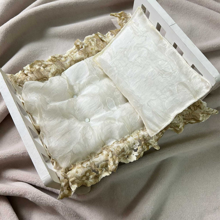 A 2-piece set featuring a newborn blanket and pillow with beige floral print and lace trim for newborn photography.