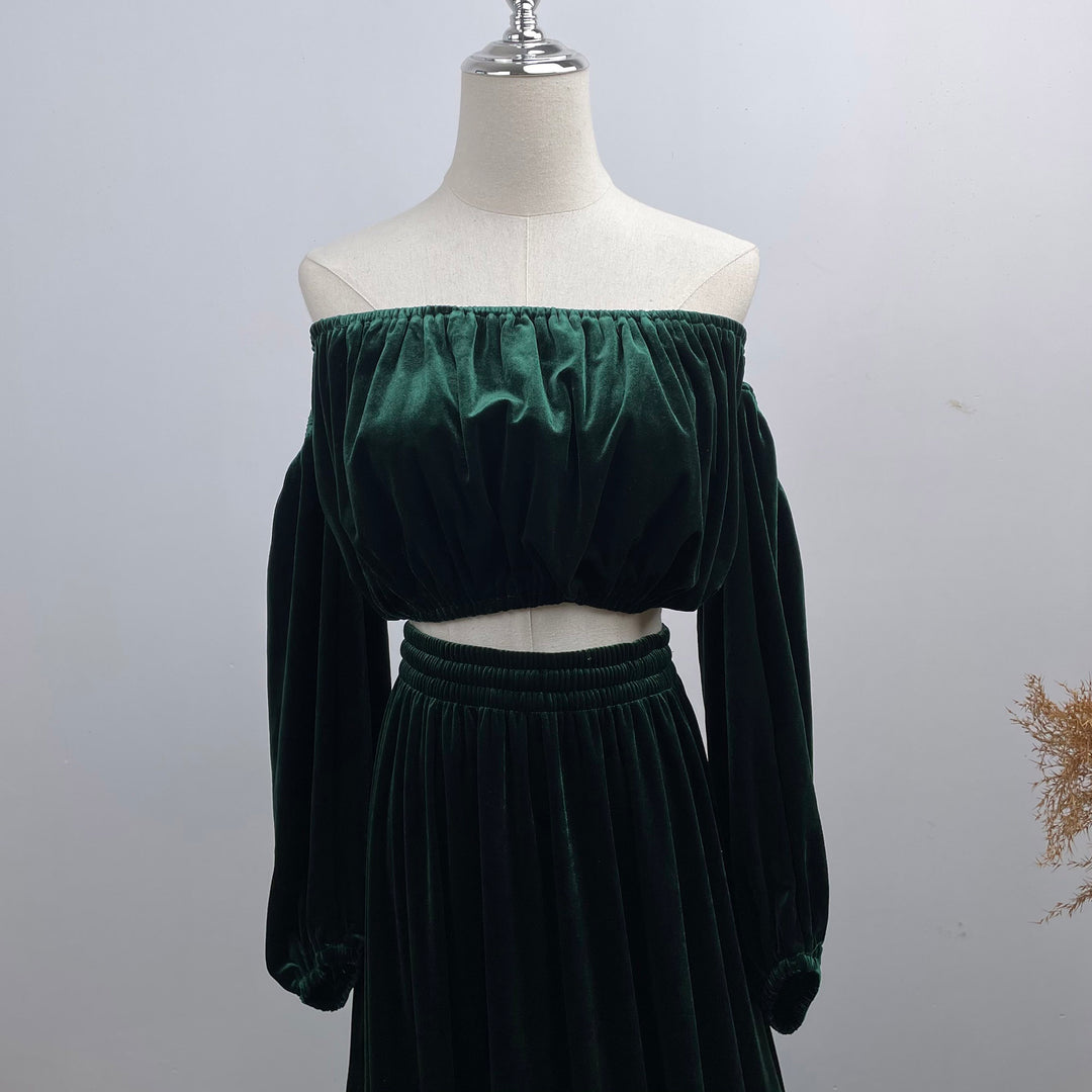 A mannequin displays a close-up of Belisama dress velvet off-shoulder top and floor-length skirt. The two-piece outfit has a ruffled skirt hem.