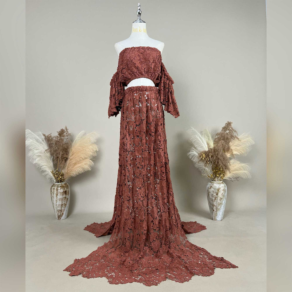 A terracotta two-piece lace maternity photography set displayed on a mannequin, featuring an off-the-shoulder ruffled crop top and a high-waisted floor-length skirt with a sweeping train