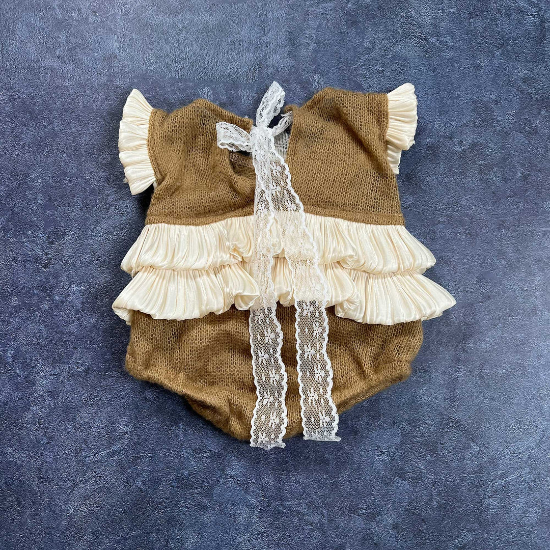The back of the romper is displayed flat, featuring camel knit fabric with a double-layer ruffled hem and lace ties hanging down the center.