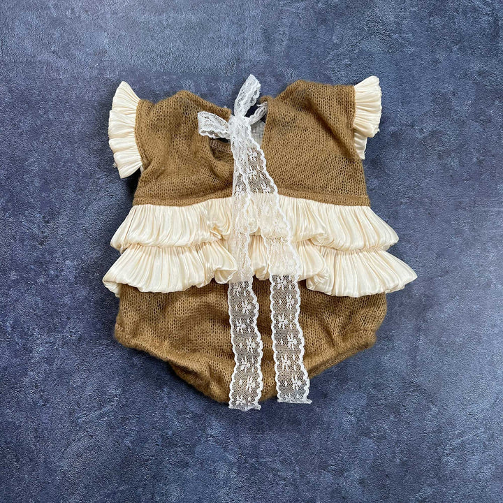 The back of the romper is displayed flat, featuring camel knit fabric with a double-layer ruffled hem and lace ties hanging down the center.