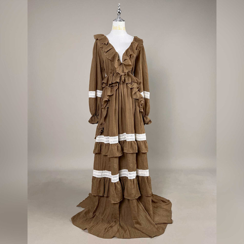 A Cassandra coffee long-sleeve tiered dress on a mannequin facing forward, train on the floor, gray background.