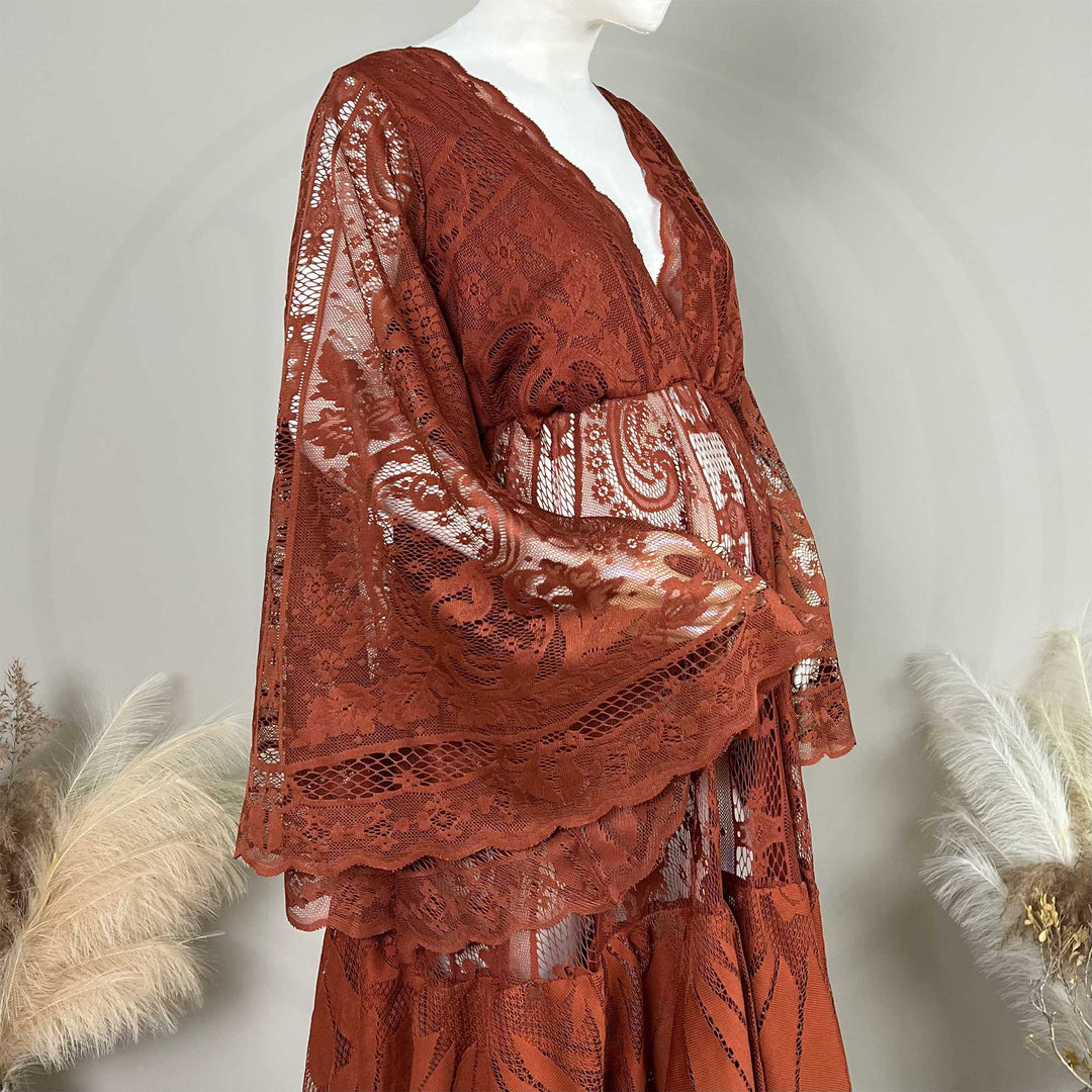 A terracotta lace maternity robe displayed on a mannequin. The garment features a V-neckline, wide bell sleeves with scalloped edges, and an open front design that reveals the midsection.