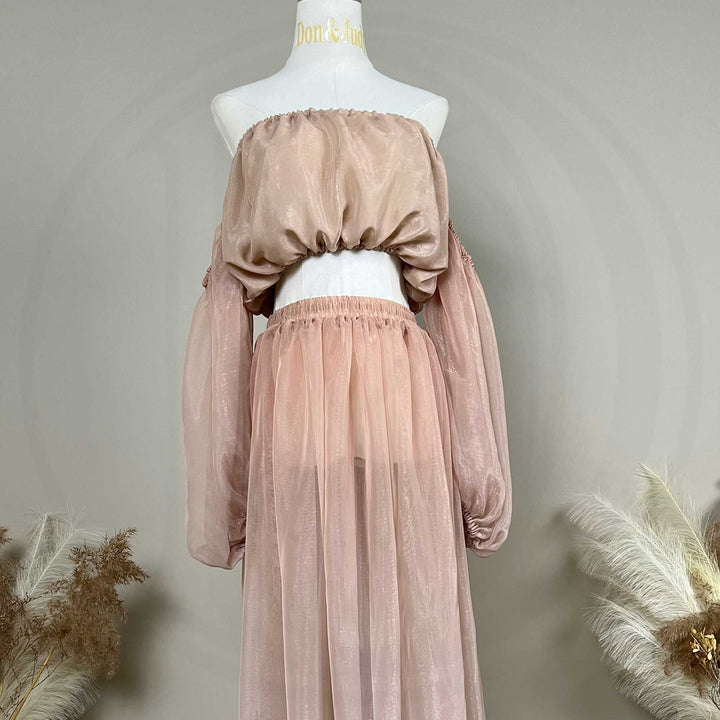 A mannequin displays a two-piece maternity set featuring an off-shoulder top and floor-length tulle skirt; the top has lantern sleeves.