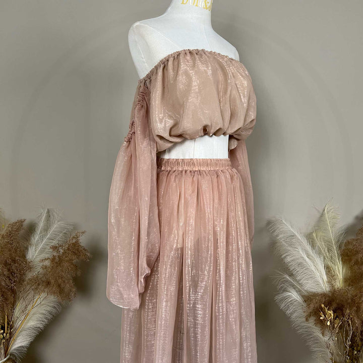 A close up of a two-piece maternity set featuring an off-shoulder top and floor-length tulle skirt.