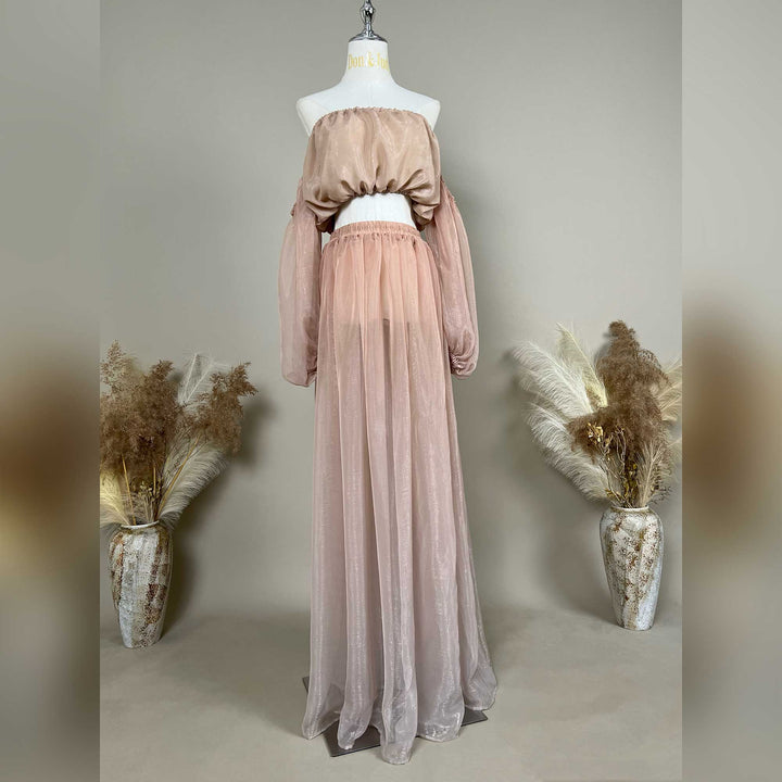 A mannequin displays a pink two-piece maternity set featuring an off-shoulder top and floor-length tulle skirt.