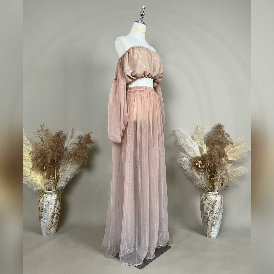 A mannequin a side view of a two-piece maternity set featuring an off-shoulder top and floor-length tulle skirt.