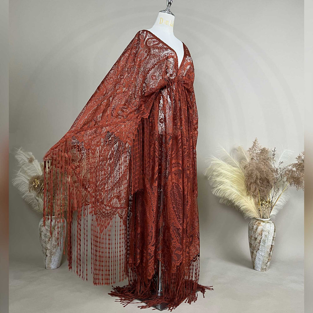 A mannequin shows a side view of a terracotta lace cape featuring floral openwork texture and a deep V-neck; the fabric is semi-transparent mesh
