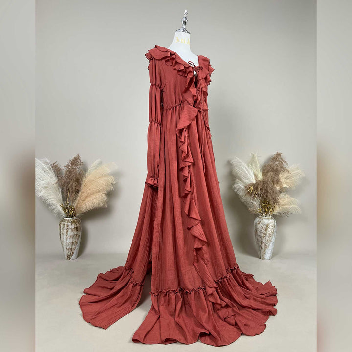 A Terracotta, Kallectoria dress with ruffle details is displayed on a mannequin against a neutral gray background