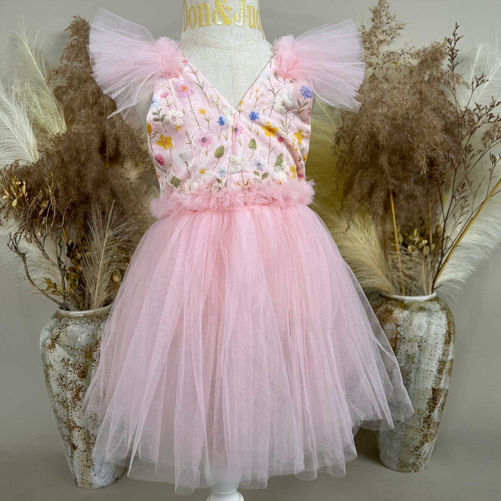 A mannequin displays a pink V-neck sleeveless dress with 3D floral embroidery and tulle cap sleeves; the skirt consists of layered pink tulle.