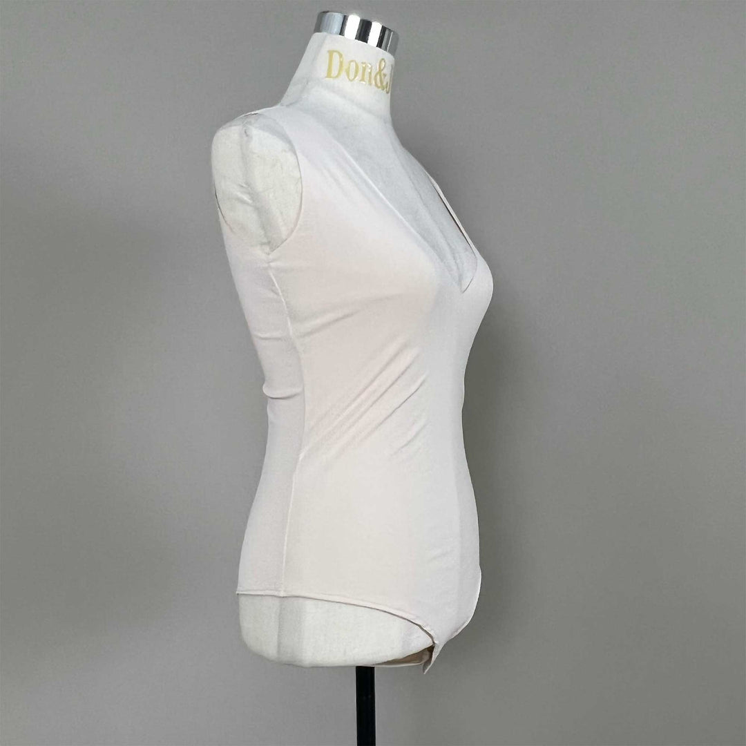 A mannequin shows a side view of a skin sleeveless bodysuit, revealing the V-neck silhouette and fitted cut; the hem features a curved high-cut design