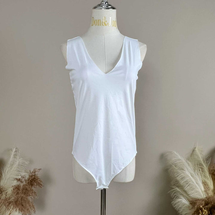 A mannequin displays a white sleeveless V-neck bodysuit with a high-cut hem.