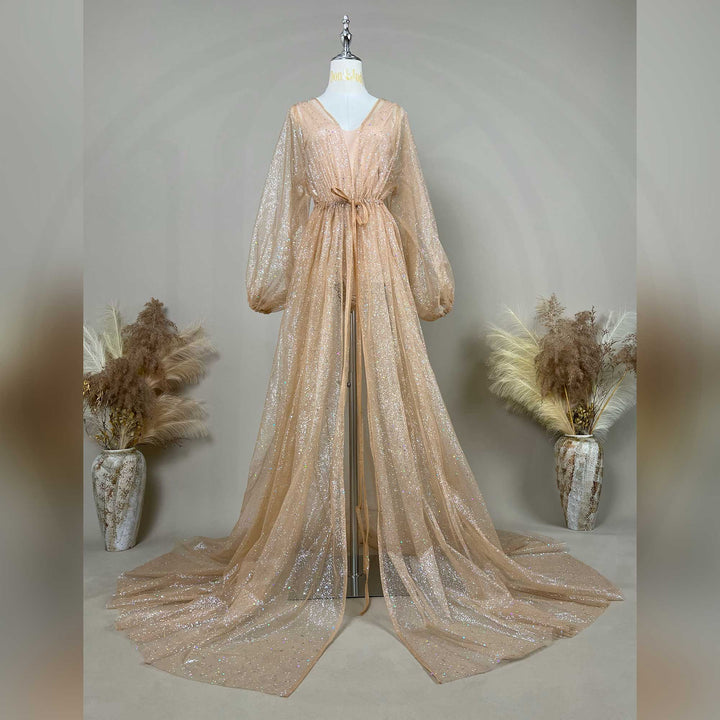 A mannequin displays a champagne sequined robe with a tie waist and lantern sleeves; the dress features a split train