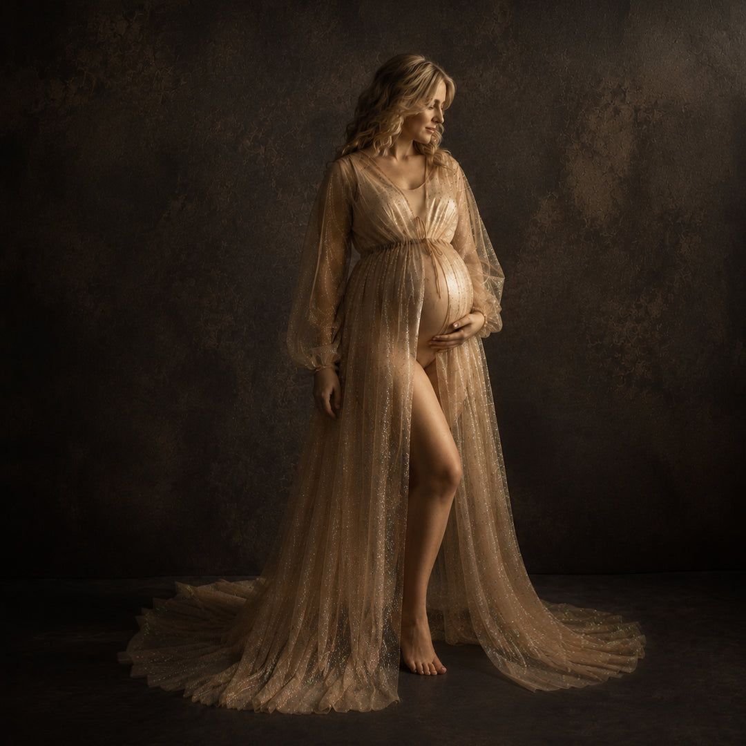 A pregnant model in a khaki sequined V-neck robe stands against a dark background, wearing a light bodysuit underneath with one hand on her belly; the robe features lantern sleeves, a tie belt, and a floor-length train.