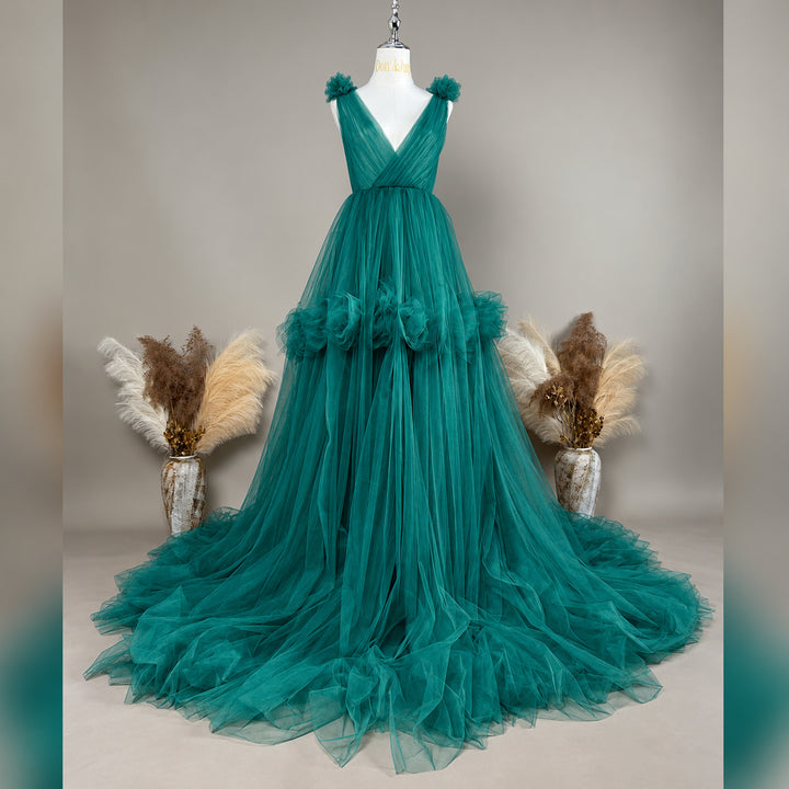 A Mila Color 13 tulle gown is displayed on a mannequin with floral details on the shoulders, waist, and neckline. 