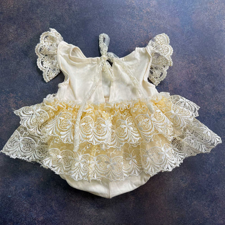 A close-up view of the Modal soft yellow double layer embroidered lace romper for newborn photography.
