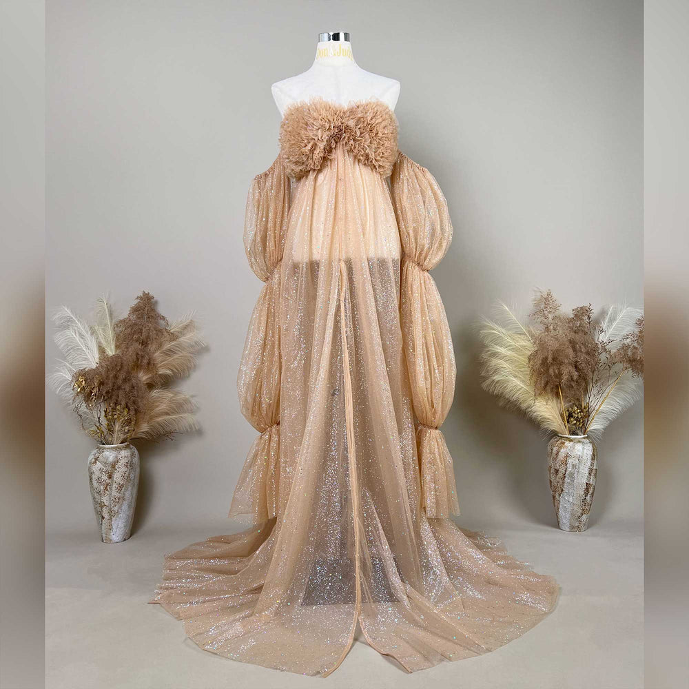 A mannequin displays a khaki sequined off-shoulder gown with feather chest decor and segmented puff sleeves.