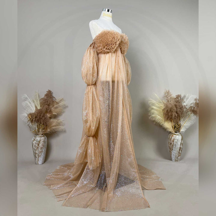 A mannequin displays a khaki sequined off-shoulder gown with feather chest decor and segmented puff sleeves.