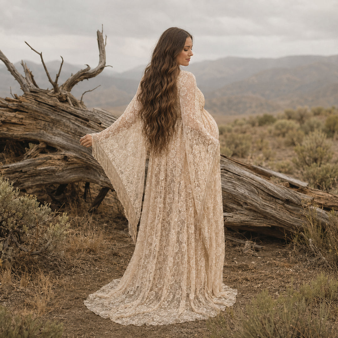 pregnant woman in a khaki lace fringe gown stands with back to camera before deadwood, showing sleeve fringe.
