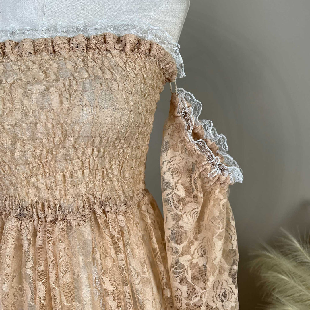 A close-up of the khaki lace dress bodice and sleeves is displayed on a mannequin, featuring horizontal shirring, rose patterns, and white lace ruffles.