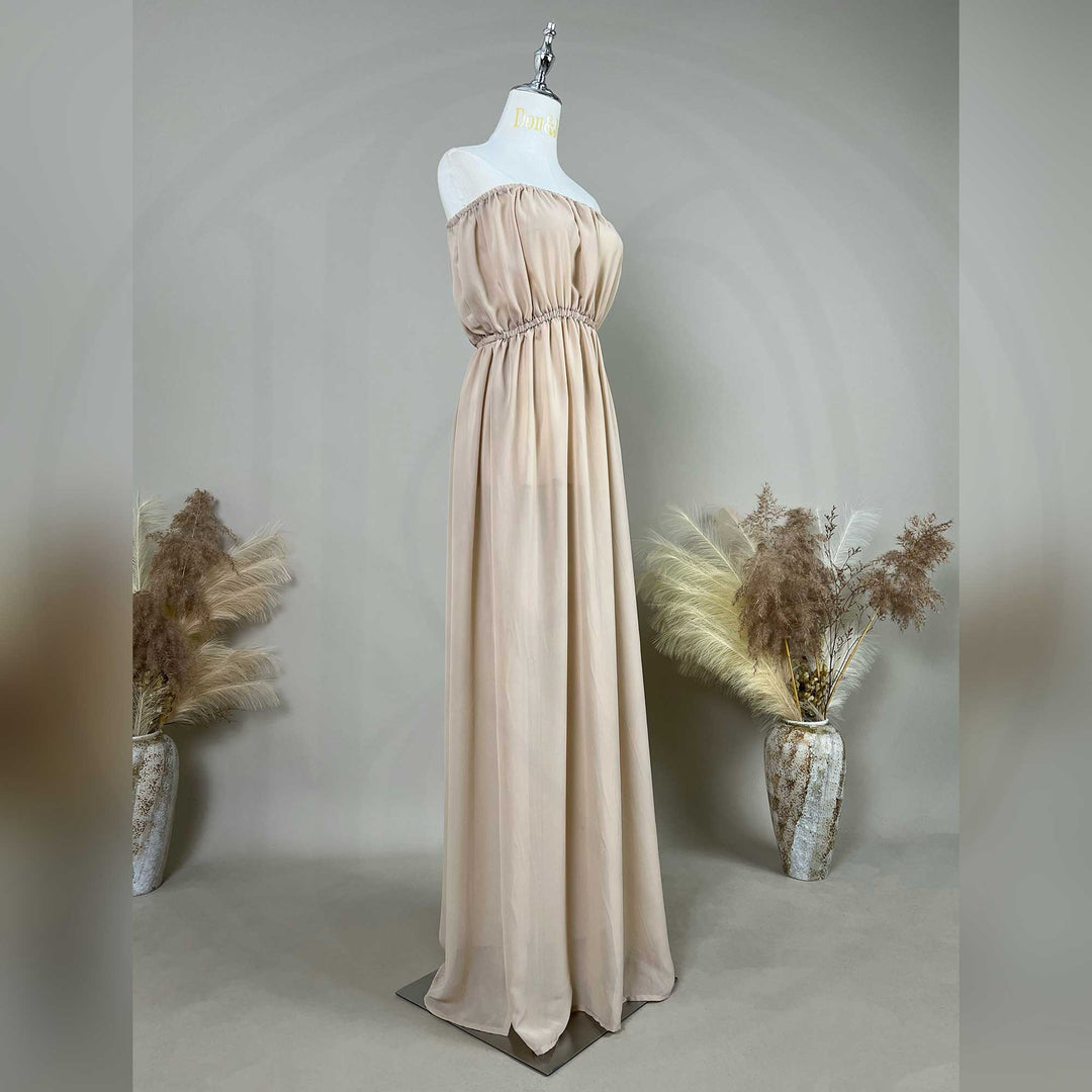 A chiffon strapless gown is displayed on a mannequin, featuring a ruched bodice, rhinestone waistline, and draped skirt.