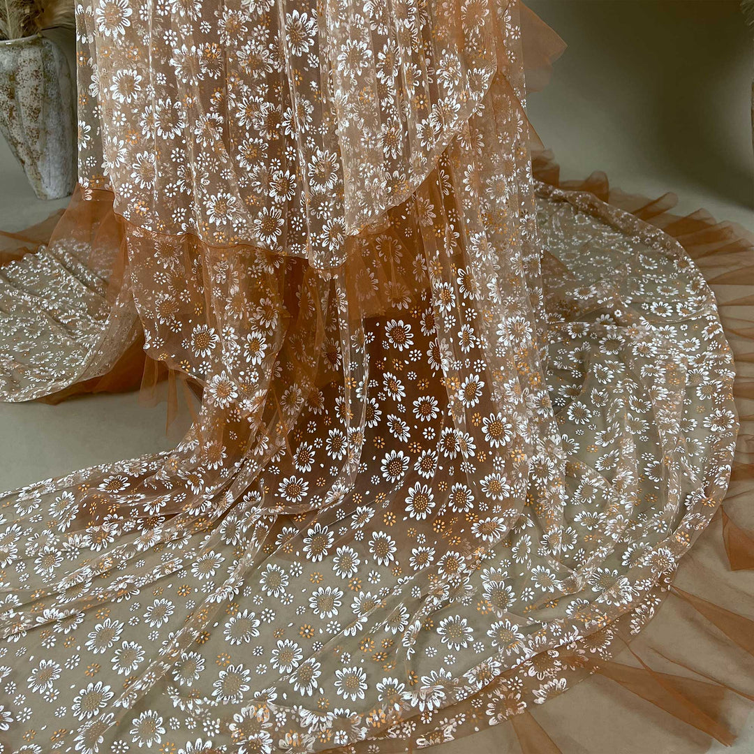 The close up of white daisy prints on the fabric and layered ruffled edges.