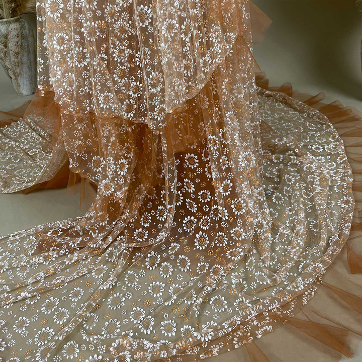 The close up of white daisy prints on the fabric and layered ruffled edges.